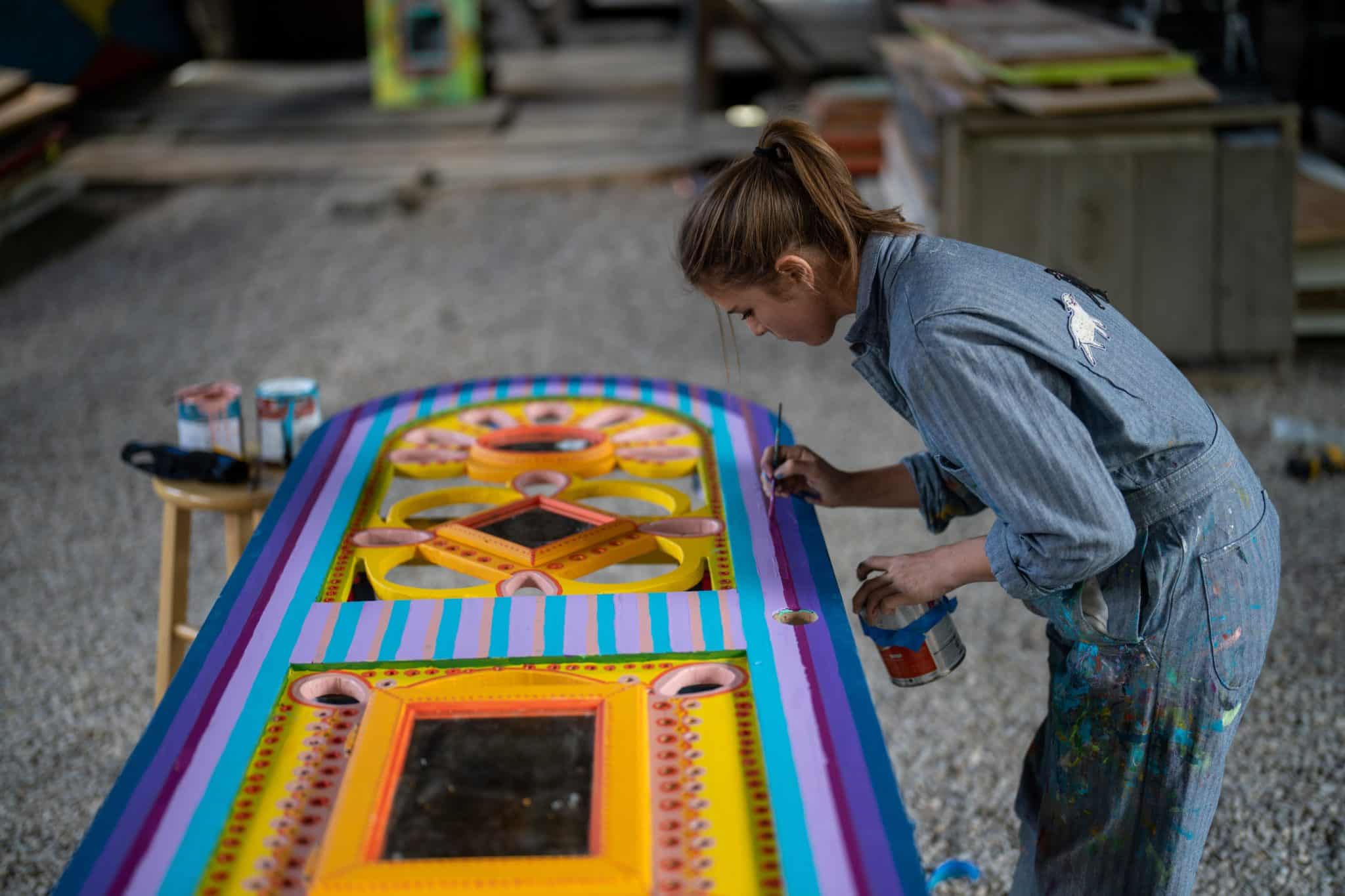 Artist Brooke Einbender painting a door for an installation