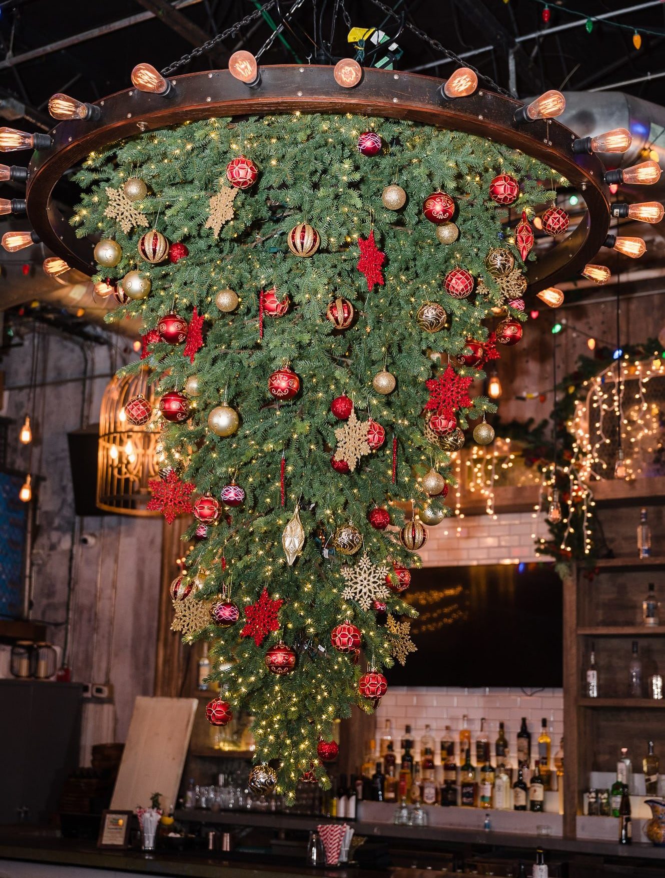 An upside down Christmas tree hanging from the Bodega chandelier