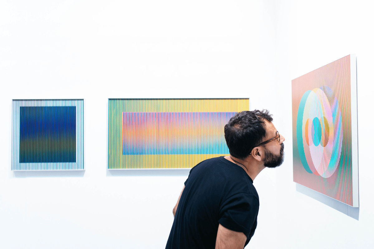 A man looks closely at artwork