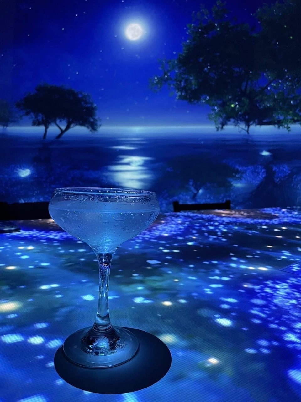 A drink set on a table with a projected seascape
