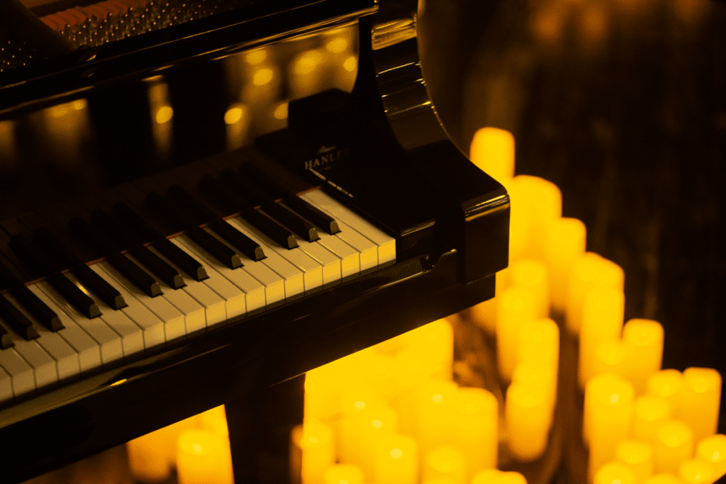 A close up of a grand piano with countless candles surrounding it