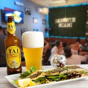 Beer and plate inside Namaste Miami 