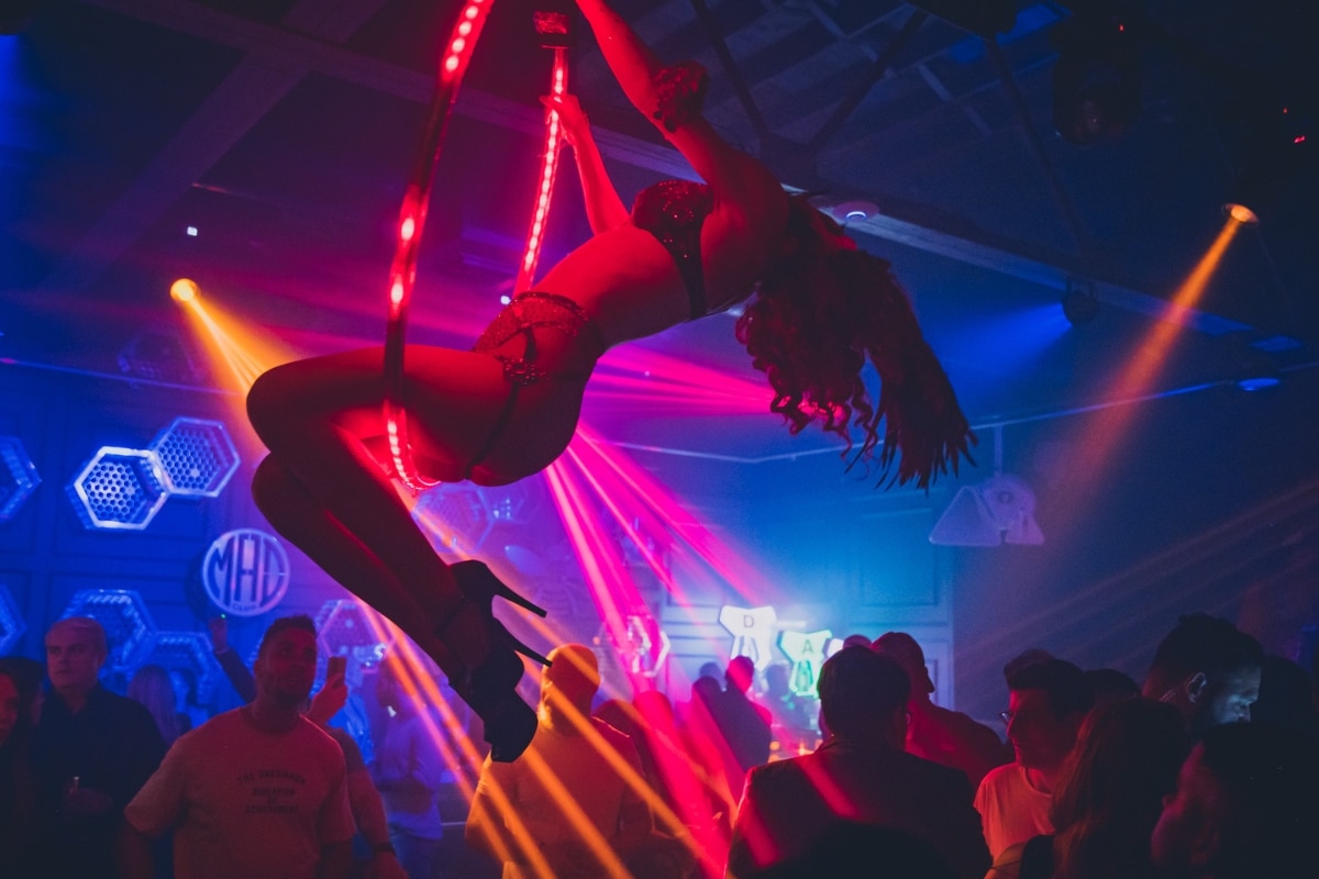An aerial performer hangs from the ceiling at Mad Club Wynwood