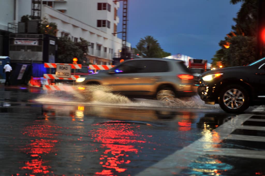 Cars moving on flooded streets and roads of Miami South Beach after heavy rains in Miami Beach, Florida