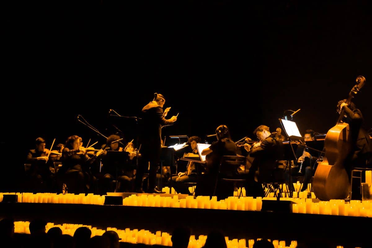 A Candlelight Orchestra performing on a stage in the glow of hundreds of flickering candles.