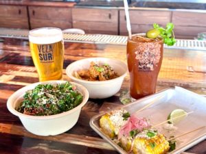 Cocktails, beer and food on a table at Veza Sur Brewing Co.